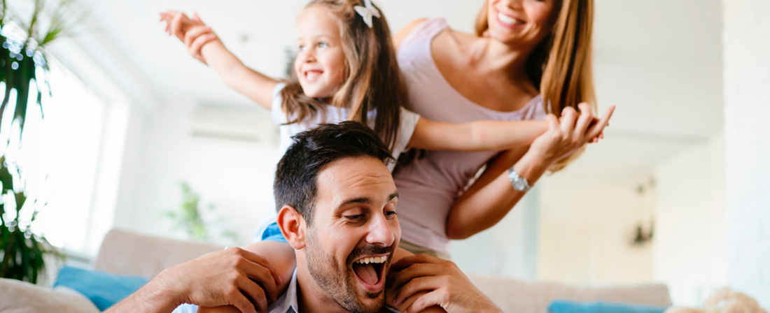 Madre y padre con su hija sobre los hombros