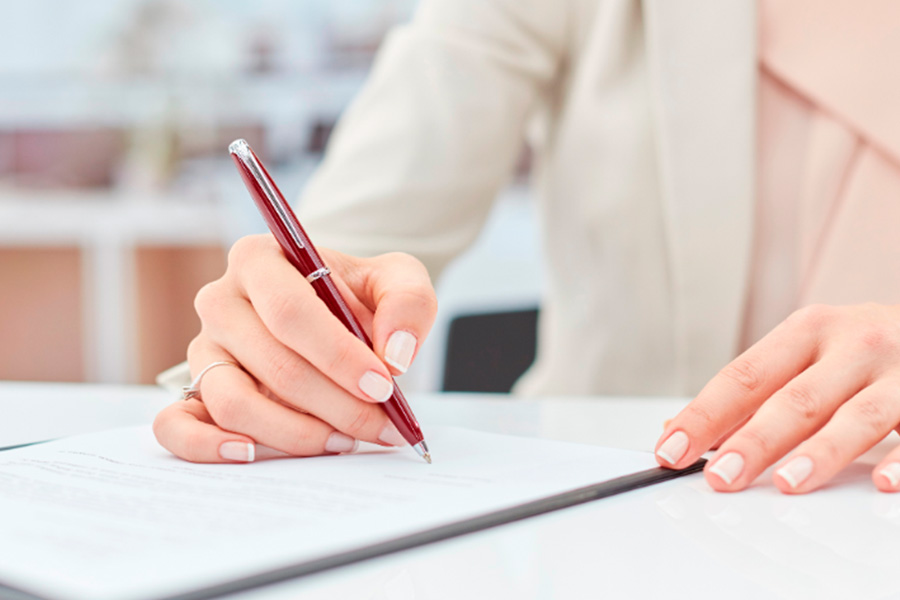 Mujer firmando un documento en primer plano